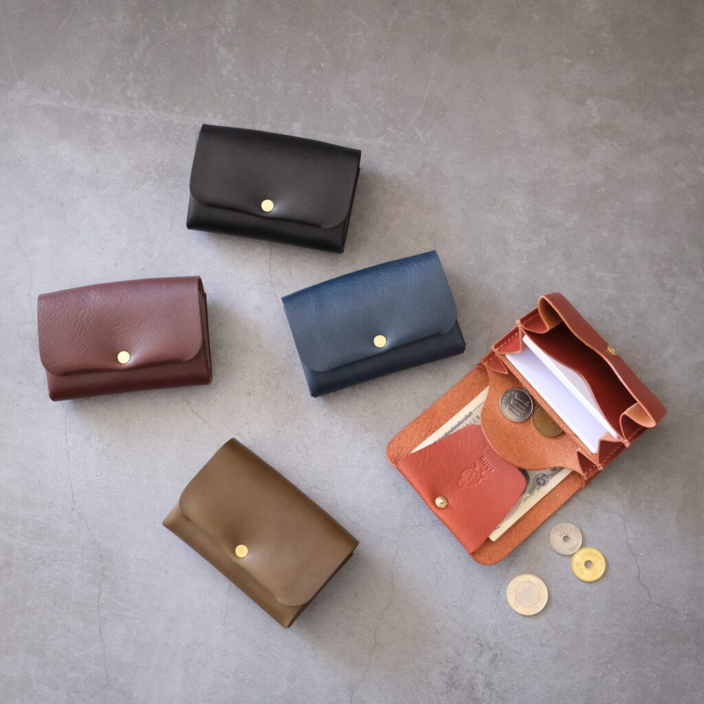 東京の職人が仕立てる、イタリアンレザーの財布やキーケース。革靴作りと同じ頑丈なステッチが特徴で、革製品の初心者にもおすすめの温もりある小物です。黒、紺、茶など色とりどりのアイテムが並び、使い込むほどに自分だけの色に育つ経年変化を楽しめます。